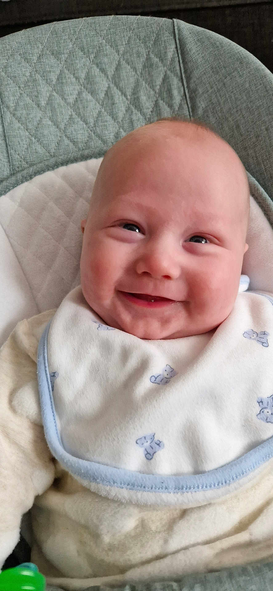 Archie is registered to the contest to win money with this photo: baby, smiling, bib, clothing, infant, face, child, cute, happy, seat, cushion, soft, indoor, portrait, young, small, toddler, comfort, wearing, closeup