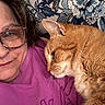 cat, close_up, companion, cozy, cute, eyewear, face, floral_background, fur, ginger_cat, glasses, home, indoor, person, pet, portrait, purple_sweatshirt, relaxed, snuggling, whiskers