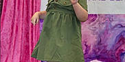 Ileanna joined the competition — help win amazing prizes! toddler, child, dress, green_dress, hat, curly_hair, boots, sparkly_boots, stage, pink_curtain, background_banner, posing, smiling, indoor, fashion, person, footwear, cute, happy, event