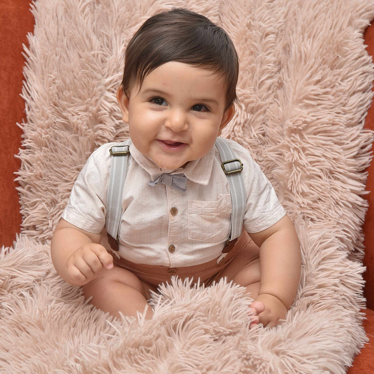 Yassine a rejoint le concours — aidez-le/la à gagner de superbes lots ! adorable, baby, bow_tie, candid, chair, child, cute, face, fluffy_blanket, happy, indoor, infant, person, plush, portrait, seated, shirt, smile, soft_texture, suspenders