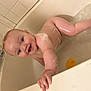 baby, bath, bathtub, water, foam, rubber_duck, child, smile, skin, hand, face, happy, playing, splash, tiled_wall, faucet, soap_bubbles, bath_time, infant, cute
