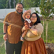 Anastasia joined the competition — help win amazing prizes! family, child, baby, outdoor, smiling, woman, man, glasses, hat, boots, grass, trees, sunlight, casual_clothing, portrait, parent, holding, happy, nature, fence