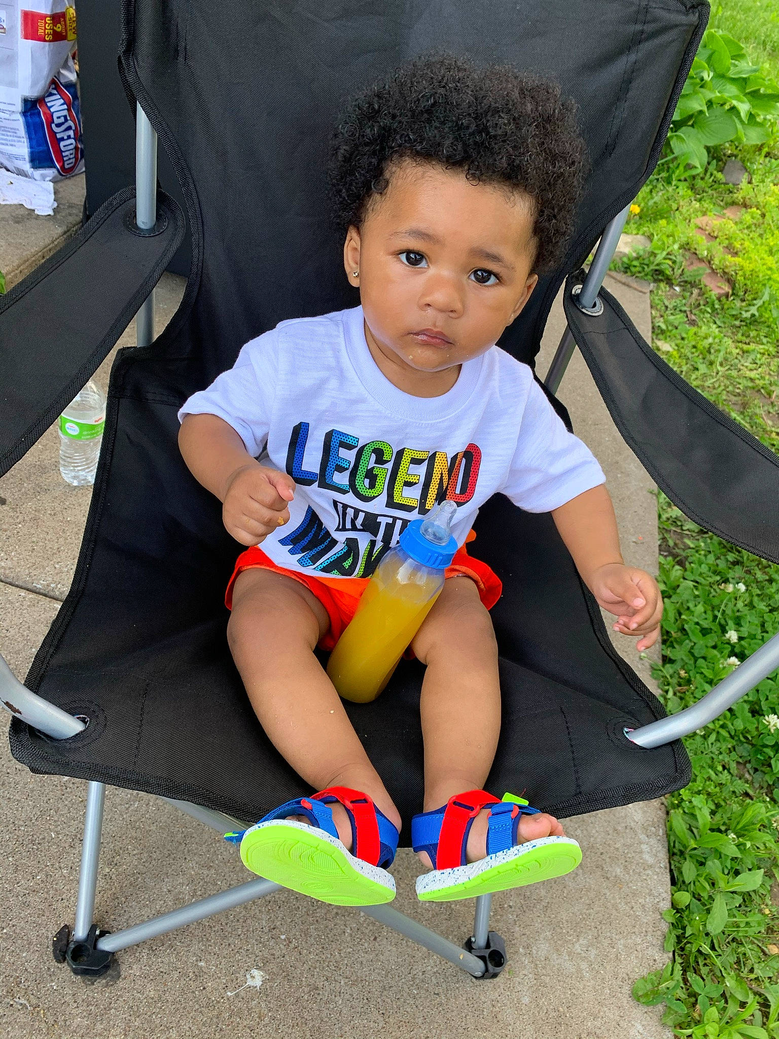 Dennis is registered to the contest to win money with this photo: baby_toddler_clothing, chair, child, electric_blue, face, fun, grass, happy, head, leisure, outdoor_furniture, person, play, recreation, shorts, sitting, summer, t_shirt, thigh, toddler