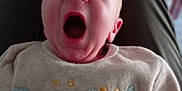 Nathan participe au concours pour gagner de l'argent avec cette photo : baby, yawning, infant, sweater, clothing, person, face, mouth_open, lap, blurred_background, indoor, cute, child, portrait, head, skin, expression, cozy, seated, casual