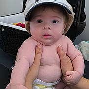 Noam participe au concours pour gagner de l'argent avec cette photo : baby, infant, hat, hands, diaper, car_seat, indoor, person, child, cute, wide_eyes, chubby, skin, expression, holding, fingers, face, headwear, clothing, human