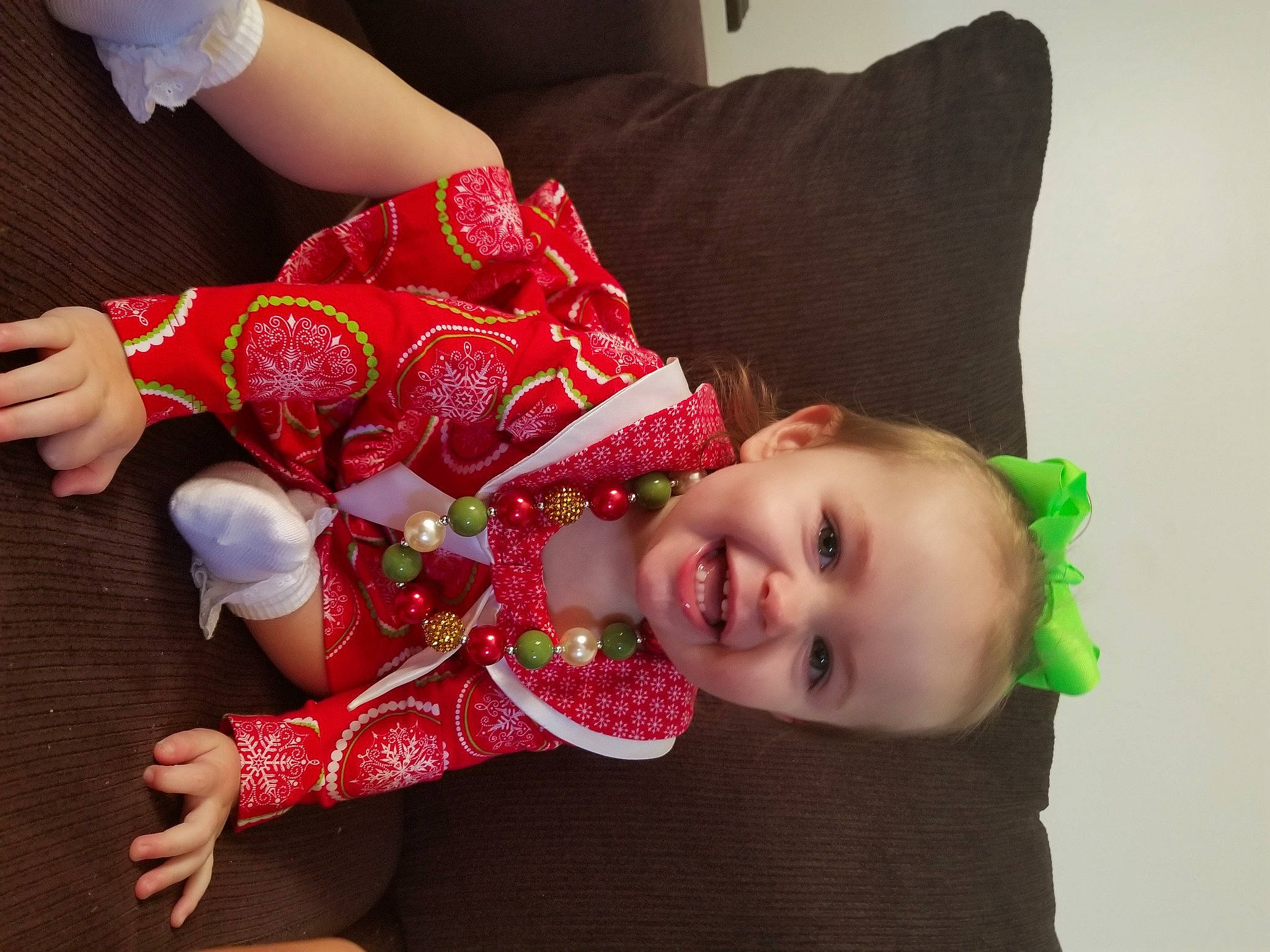 Karlee is registered to the contest to win money with this photo: baby_toddler_clothing, child, christmas, event, face, flooring, fun, happy, holiday, human_leg, joy, nail, pattern, person, room, sleeve, smile, textile, thigh, toddler