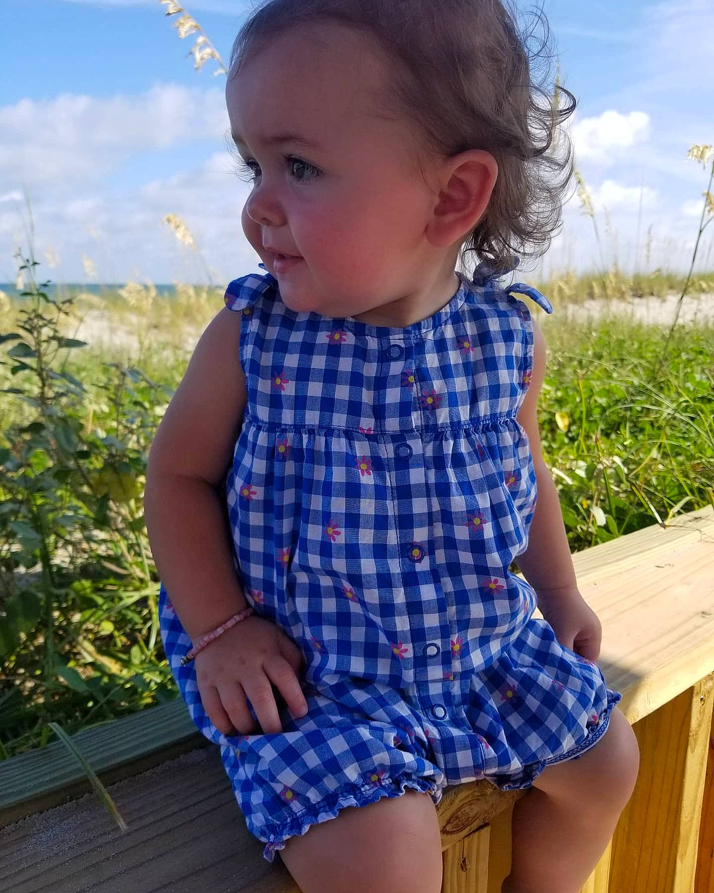 Karlee is registered to the contest to win money with this photo: azure, baby_toddler_clothing, blue, cloud, face, facial_expression, green, hair, hairstyle, head, iris, neck, person, plaid, plant, shoulder, skin, sky, sleeve, tartan
