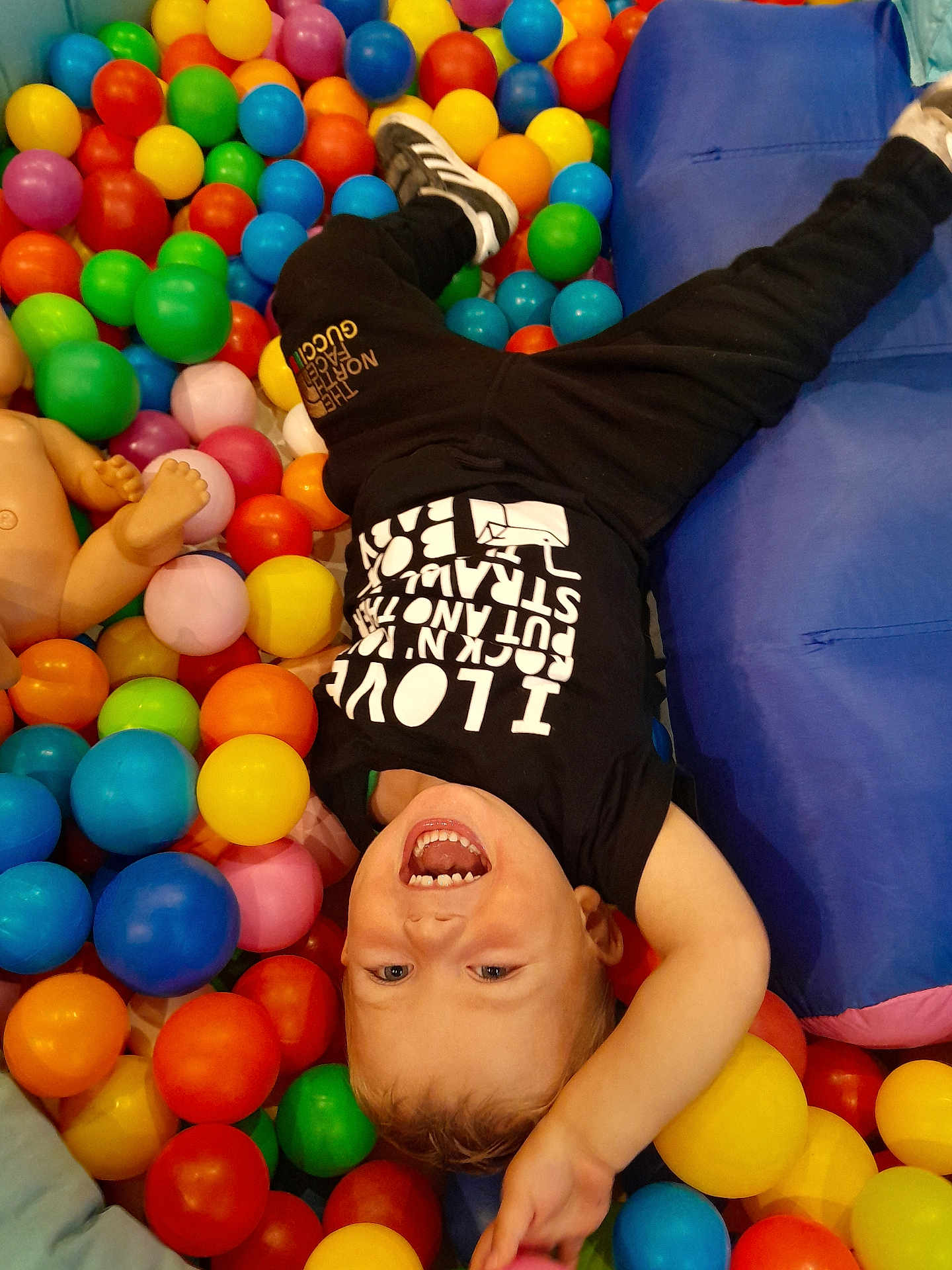 Trent joined the competition — help win amazing prizes! toddler, child, ball_pit, colorful_balls, laughing, upside_down, black_shirt, black_pants, indoor, play, fun, happy, smiling, cushion, plastic_balls, casual_clothing, young_child, joyful, play_area, active