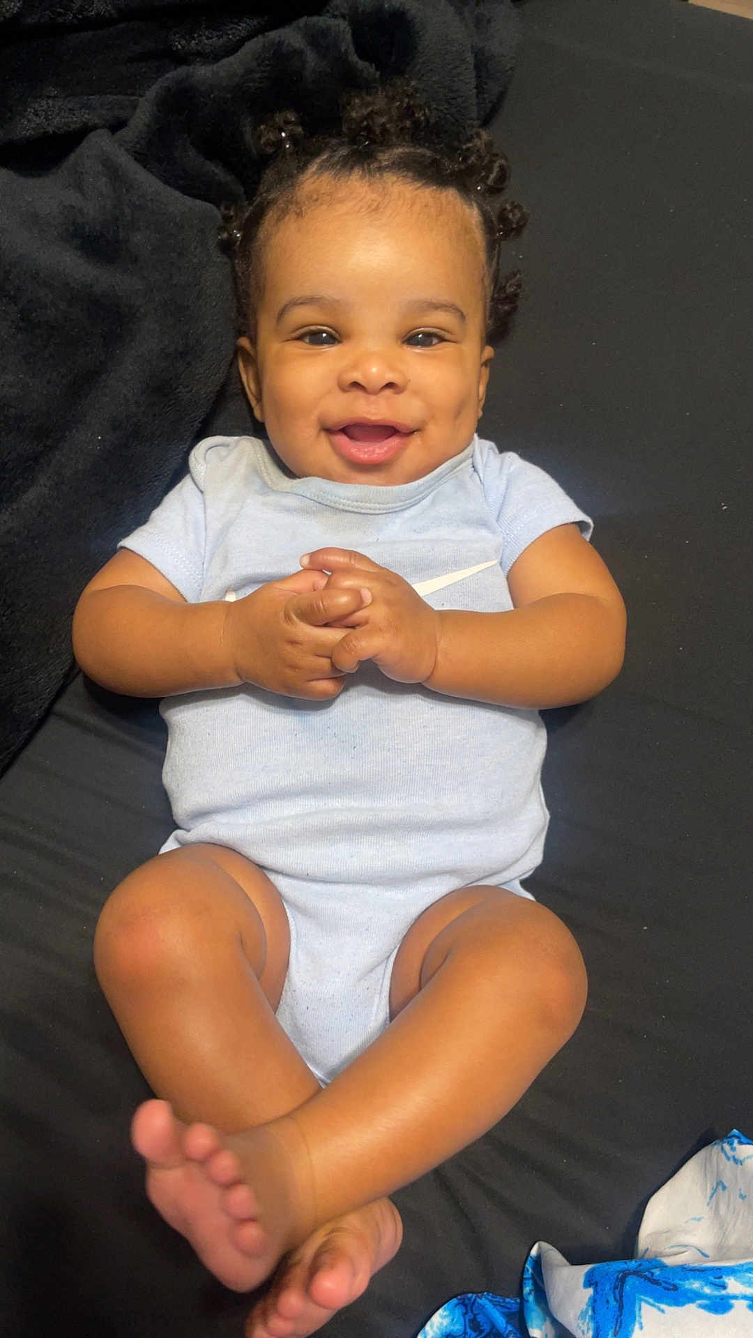 Arcangel is registered to the contest to win money with this photo: baby, smiling, curly_hair, onesie, infant, hands, legs, feet, black_background, happy, cute, child, skin, portrait, lying_down, infant_clothing, playful, dimples, young_child, indoors