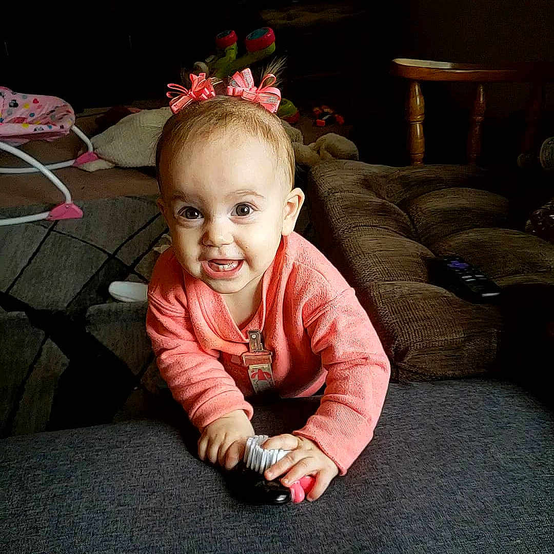 Halle is registered to the contest to win money with this photo: arm, baby, cheek, child, crawling, ear, eye, face, flooring, fun, head, joy, person, photography, pink, play, sitting, skin, smile, snapshot