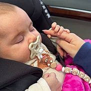 Leya a rejoint le concours — aidez-le/la à gagner de superbes lots ! baby, car_seat, pacifier, sleeping, hand, finger, blanket, pink, child, infant, seatbelt, clothing, car_interior, person, cute, closeup, peaceful, holding, accessory, transportation