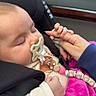 baby, car_seat, pacifier, sleeping, hand, finger, blanket, pink, child, infant, seatbelt, clothing, car_interior, person, cute, closeup, peaceful, holding, accessory, transportation