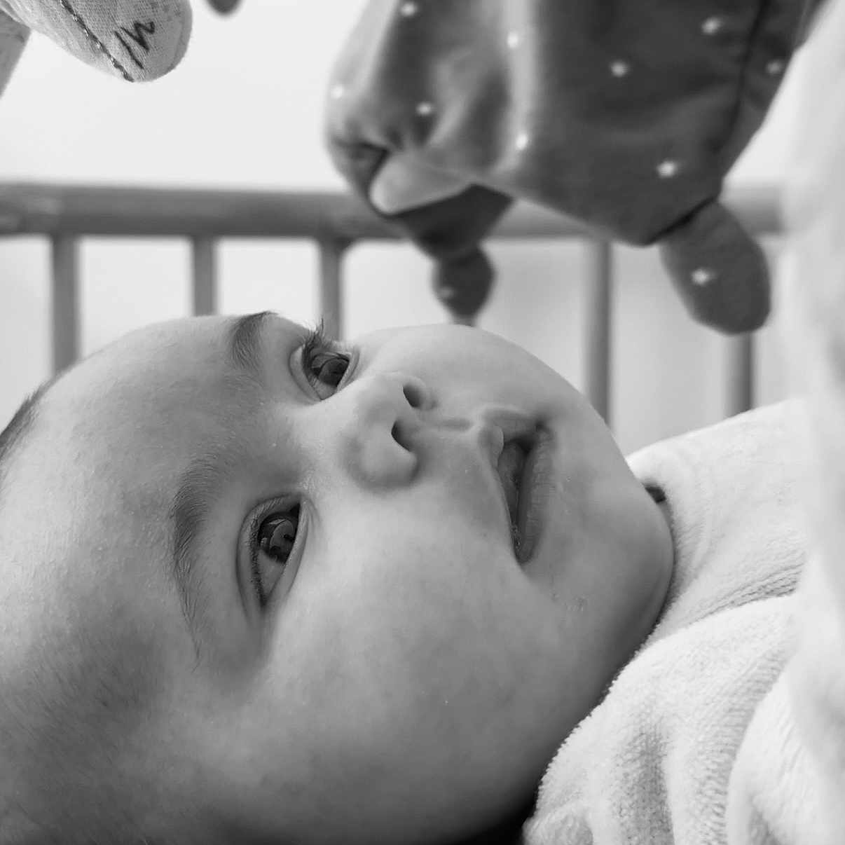 Leya participe au concours pour gagner de l'argent avec cette photo : baby, black_and_white, close_up, face, infant, looking_up, soft_texture, toy, crib, monochrome, portrait, child, cute, expression, sleepwear, newborn, peaceful, young, indoor, resting