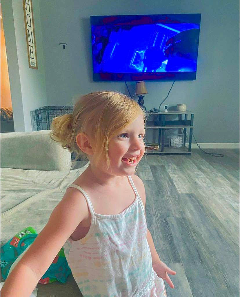 Braelynn joined the competition — help win amazing prizes! blond, display_device, electric_blue, electronic_device, entertainment, flat_panel_display, flooring, fun, gadget, happy, home_appliance, human_body, led_backlit_lcd_display, person, room, smile, standing, t_shirt, television, television_set