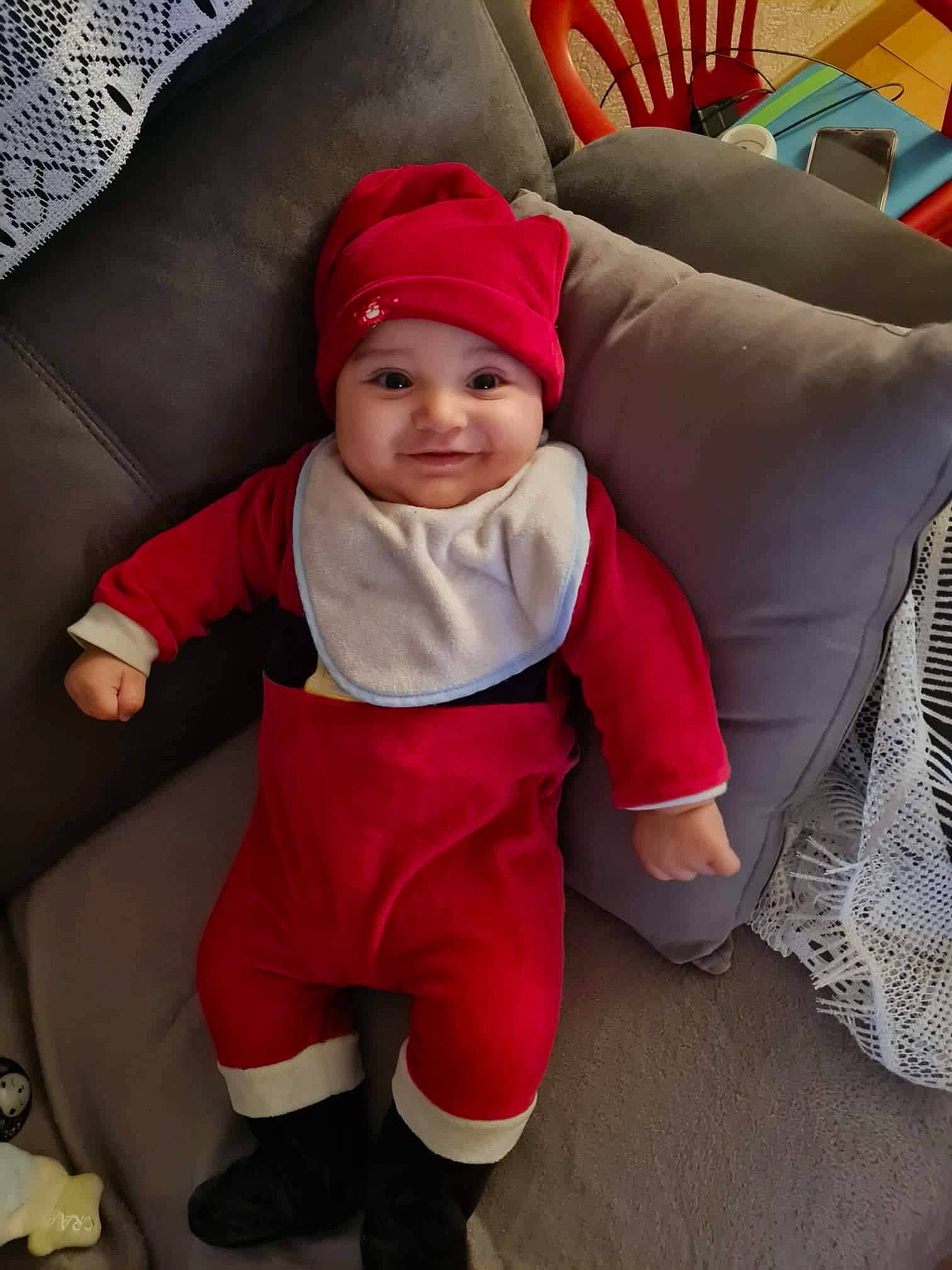 Malek participe au concours pour gagner de l'argent avec cette photo : baby, baby_toddler_clothing, cap, child, christmas, christmas_eve, comfort, fun, headgear, headwear, holiday, joy, lap, leg, outerwear, person, purple, red, sleeve, smile