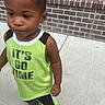 Kyrie joined the competition — help win amazing prizes! child, boy, tank_top, green_clothing, sneakers, sidewalk, brick_wall, outdoor, curious, standing, casual_wear, short_hair, young, person, daylight, urban, fashion, expression, concrete, footwear