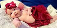 Vyvienne is registered to the contest to win money with this photo: baby, infant, red_tutu, headband, flower_headband, blanket, soft_texture, blue_background, cute, portrait, lying_down, child, skin, newborn, adorable, small_hand, closeup, indoors, cozy, fashion