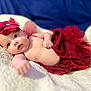 baby, infant, red_tutu, headband, flower_headband, blanket, soft_texture, blue_background, cute, portrait, lying_down, child, skin, newborn, adorable, small_hand, closeup, indoors, cozy, fashion