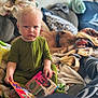 Lyall is registered to the contest to win money with this photo: child, toddler, baby, book, couch, blanket, knit_blanket, green_pajamas, dog, sleeping_dog, living_room, pillow, carpet, face, expression, hand, cozy, shallow_depth_of_field, portrait, sitting