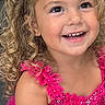 blonde_hair, bow, celebration, child, close_up, colorful, curly_hair, fashion, formalwear, girl, happy, indoors, pink_dress, portrait, sequins, smiling, sparkle, teeth, toddler, wedding_dress