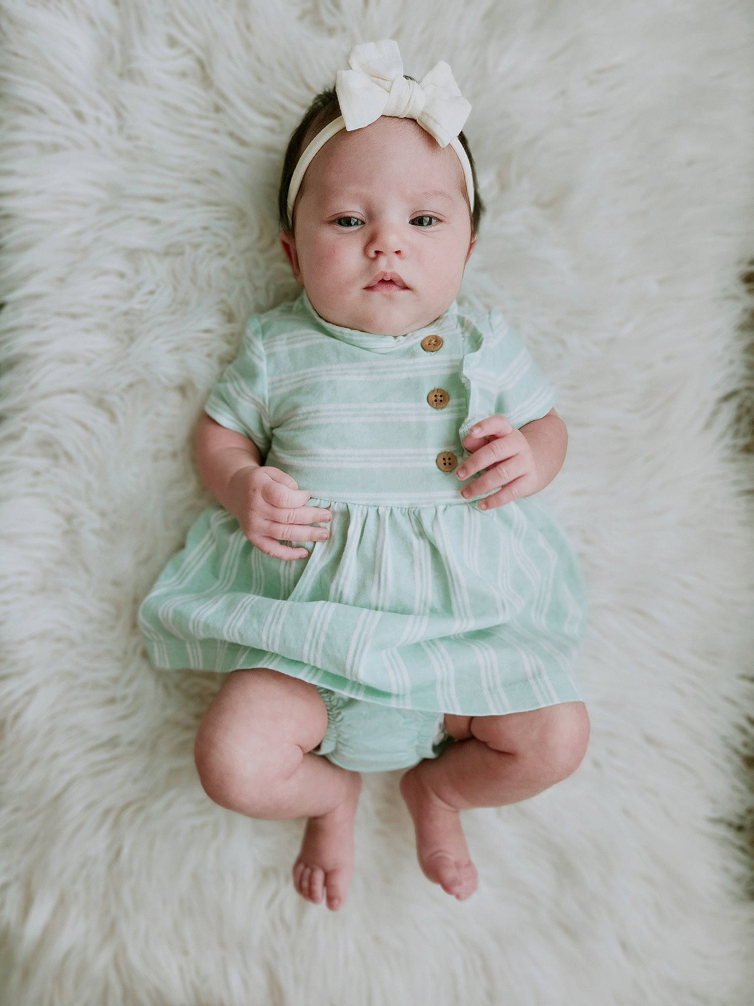 Layana is registered to the contest to win money with this photo: baby, baby_toddler_clothing, child, day_dress, dress, embellishment, face, fashion_accessory, hair_accessory, headgear, linens, one_piece_garment, pattern, peach, person, petal, pink, ruffle, sleeve, textile