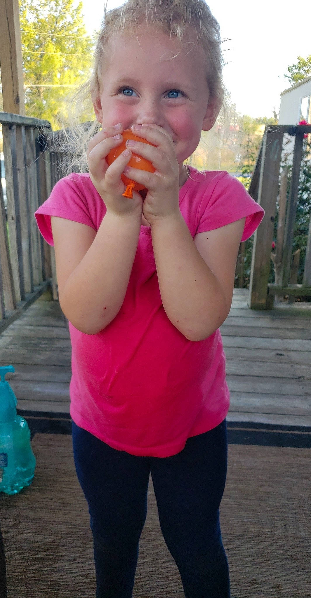 Trinity is registered to the contest to win money with this photo: biting, blue, child, fence, food_craving, fun, gesture, hand, happy, leisure, lip, magenta, mouth, nose, person, pink, plant, standing, t_shirt, thumb