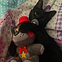 Kona joined the competition — help win amazing prizes! black_cat, plush_toy, stuffed_animal, red_hat, red_bow_tie, yellow_star, polka_dot, floral_pattern, blanket, cute, pet, animal, soft_toy, lying_down, indoor, cozy, playful, curious, paw, close_up