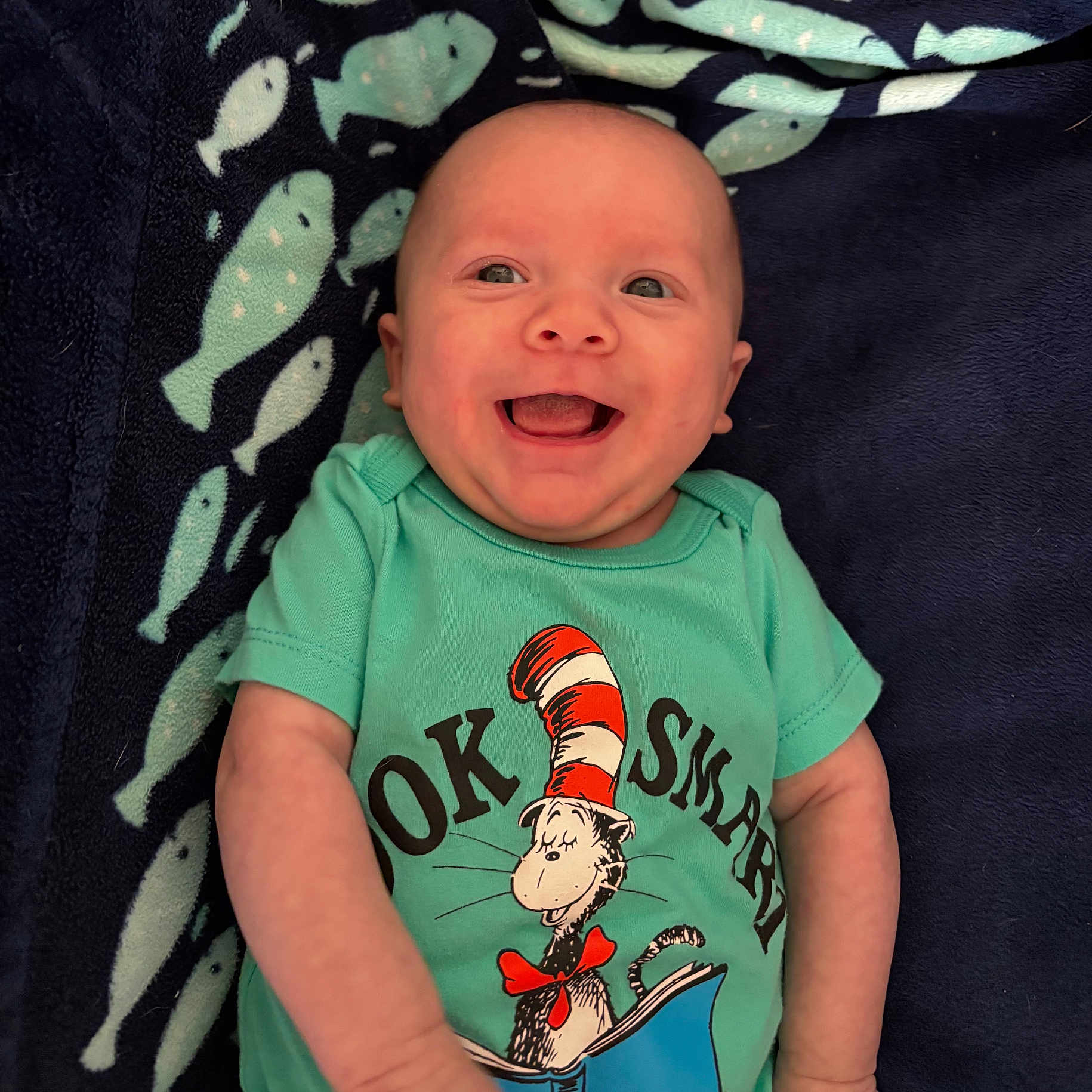 Jaxon is registered to the contest to win money with this photo: applique, baby, babylaughing, bodypart, clothing, face, happy, head, laughing, mouth, newborn, pattern, person, photography, portrait, shirt, smile, t_shirt