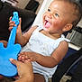 Jocelyn joined the competition — help win amazing prizes! toddler, child, smiling, happy, toy_guitar, blue_toy, indoor, carpet, person, clothing, earring, hand, playing, furniture, backpack, home, cute, joy, expression, casual