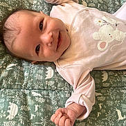 Gabrielle a rejoint le concours — aidez-le/la à gagner de superbes lots ! baby, infant, smile, face, hand, clothing, onesie, blanket, pattern, animal_print, happy, cute, lying_down, child, skin, head, small_fingers, indoor, young, person