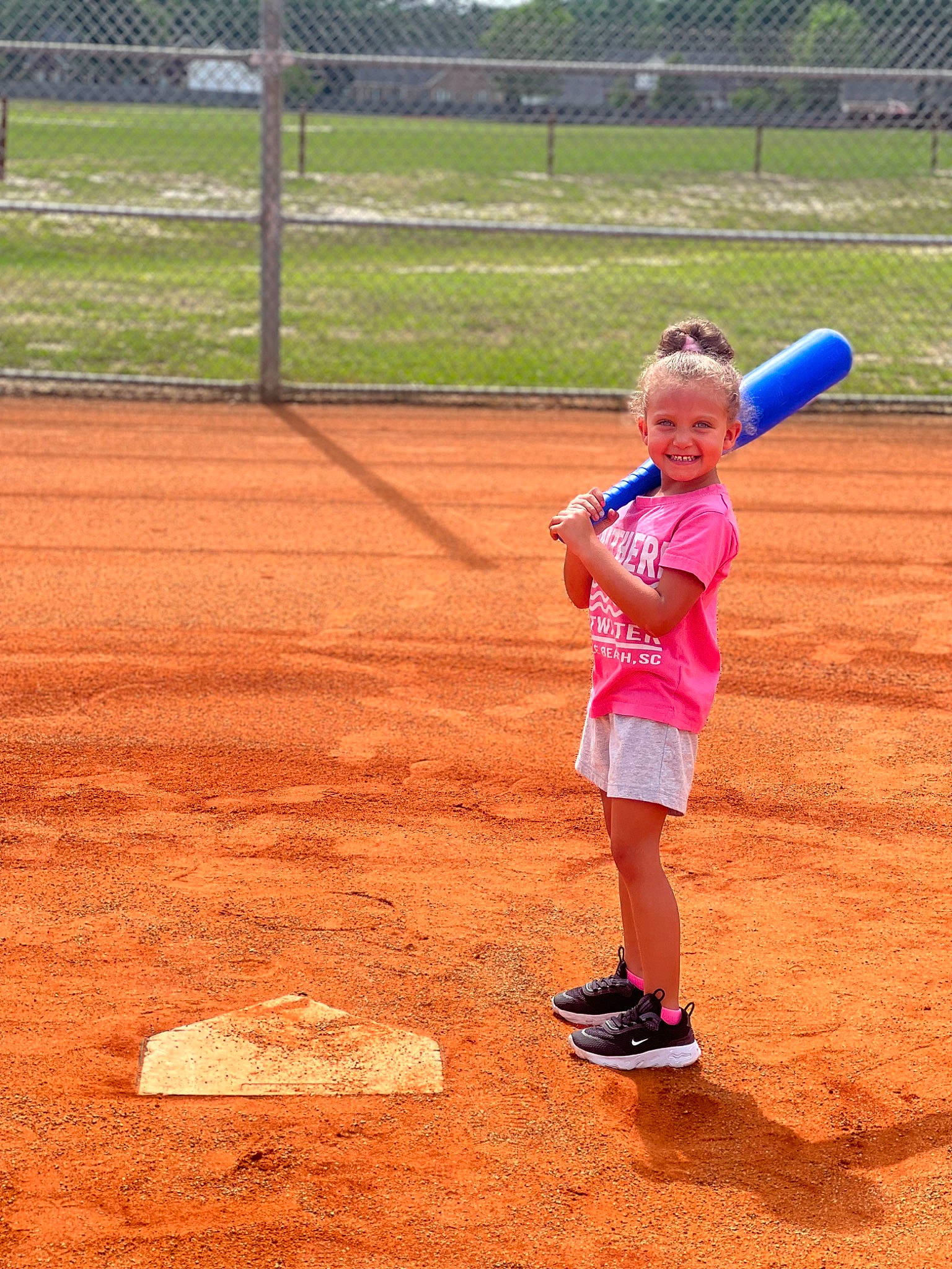 Braylee joined the competition — help win amazing prizes! athlete, baseball_equipment, bat_and_ball_games, child, competition_event, fence, footwear, fun, grass, hat, joy, leisure, people_in_nature, person, player, recreation, shorts, sneakers, sports, sports_equipment