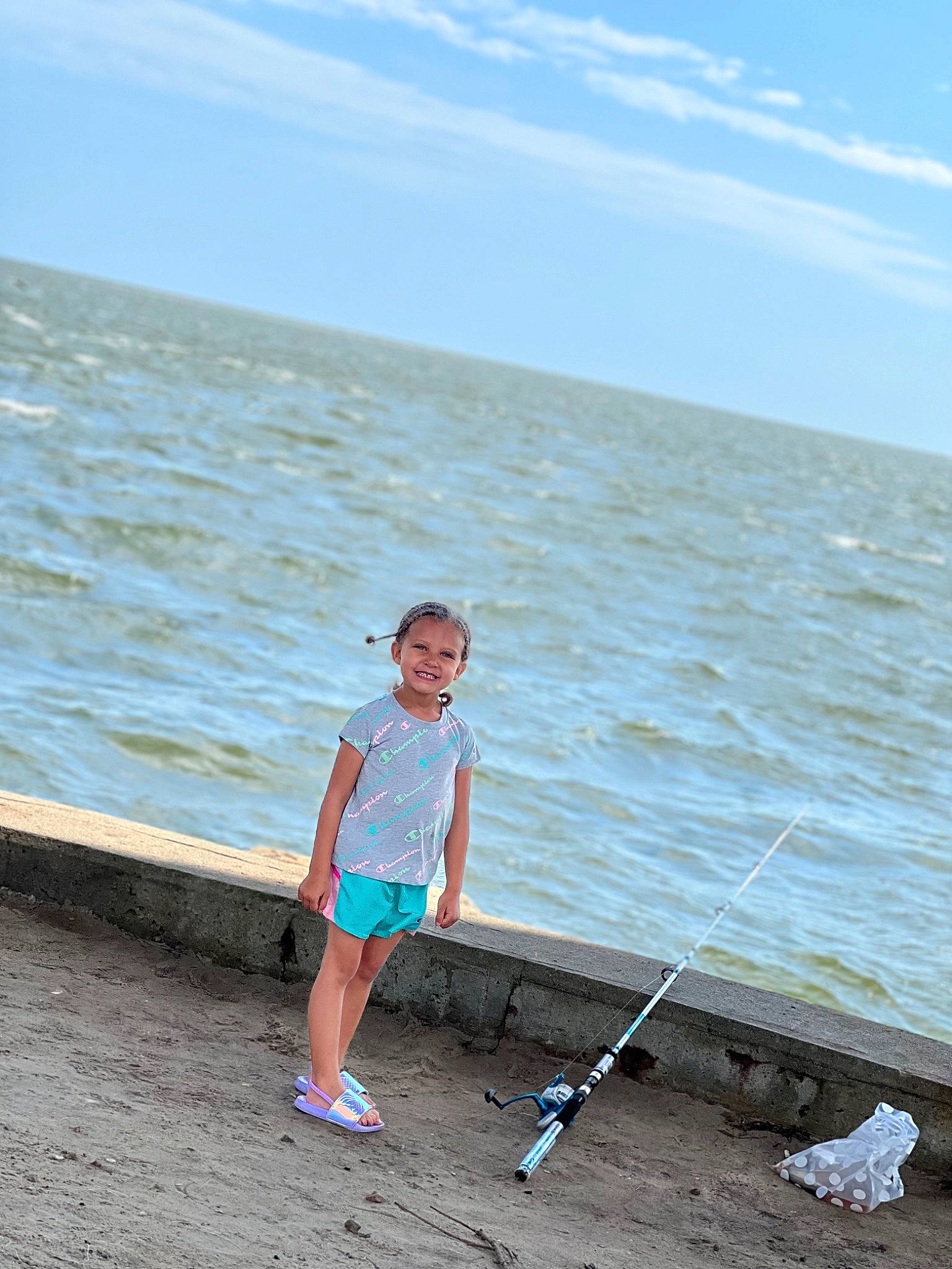 Braylee is registered to the contest to win money with this photo: azure, balance, beach, cloud, electric_blue, fun, happy, horizon, joy, lake, leisure, people_in_nature, person, recreation, shore, shorts, sky, summer, toddler, travel