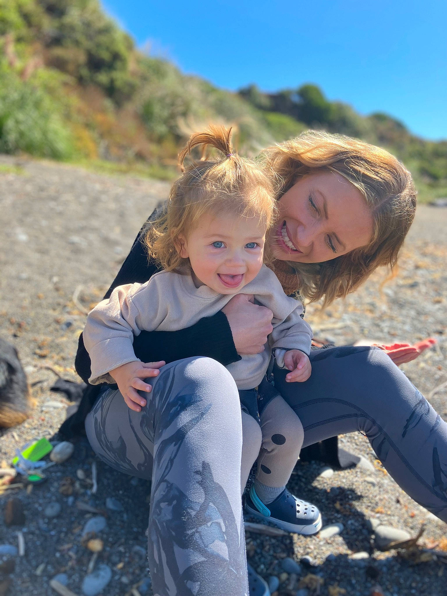 Porter is registered to the contest to win money with this photo: blond, boot, child, fun, grass, happy, joy, landscape, leisure, people_in_nature, person, recreation, rock, sitting, sky, smile, soil, toddler, tourism, travel