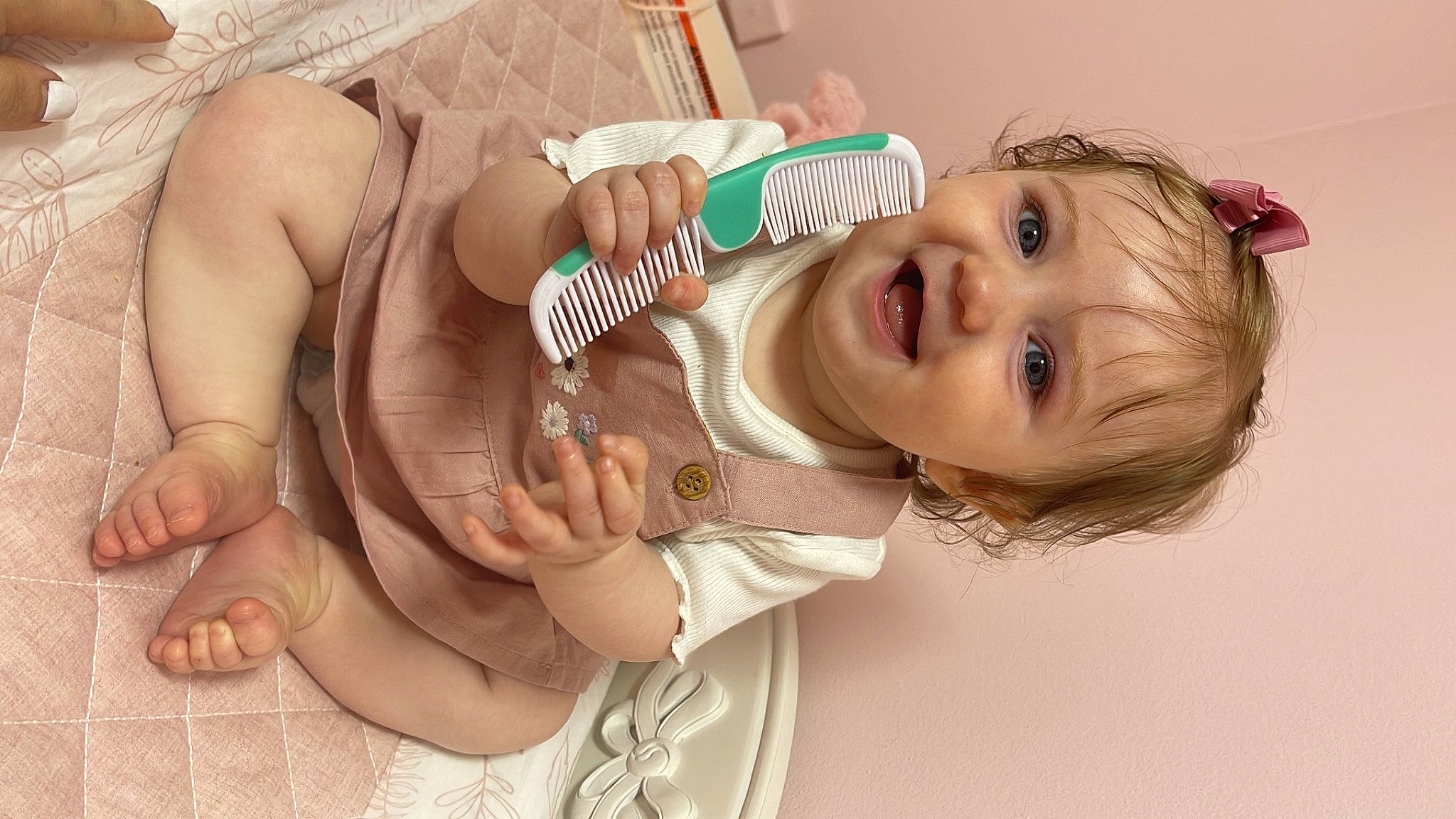Olivia is registered to the contest to win money with this photo: arm, baby, baby_toddler_clothing, eye, eyelash, gesture, hair, happy, headgear, human_body, lip, mouth, nail, neck, nose, person, pink, skin, smile, thumb