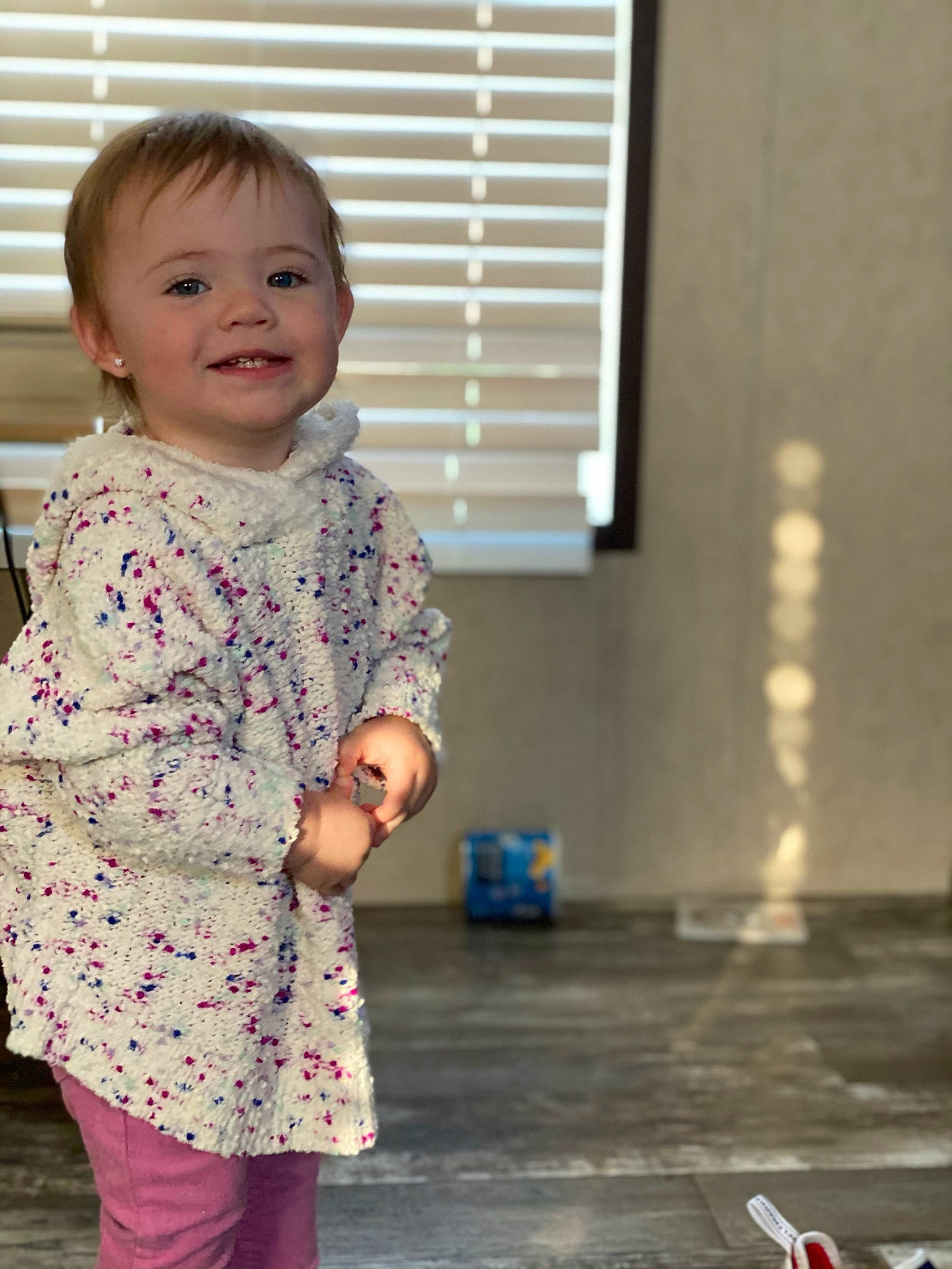 Haizley is registered to the contest to win money with this photo: baby, baby_toddler_clothing, child, floor, flooring, joy, laugh, mouth, pattern, person, pink, sleeve, standing, toddler, window_blind, window_covering, window_treatment