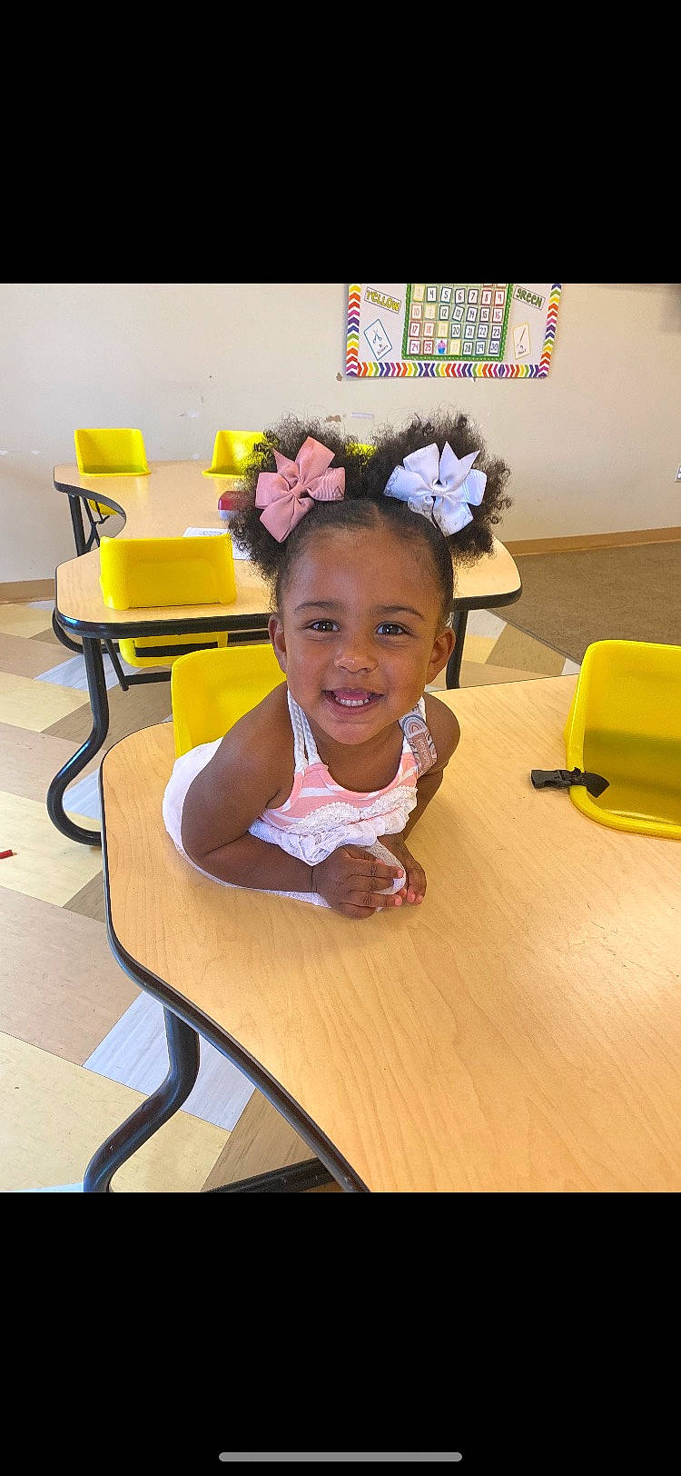 Kaisley is registered to the contest to win money with this photo: chair, child, event, eye, fashion_accessory, flooring, fun, furniture, happy, hardwood, joy, leisure, person, room, sitting, smile, sock, table, thigh, toddler