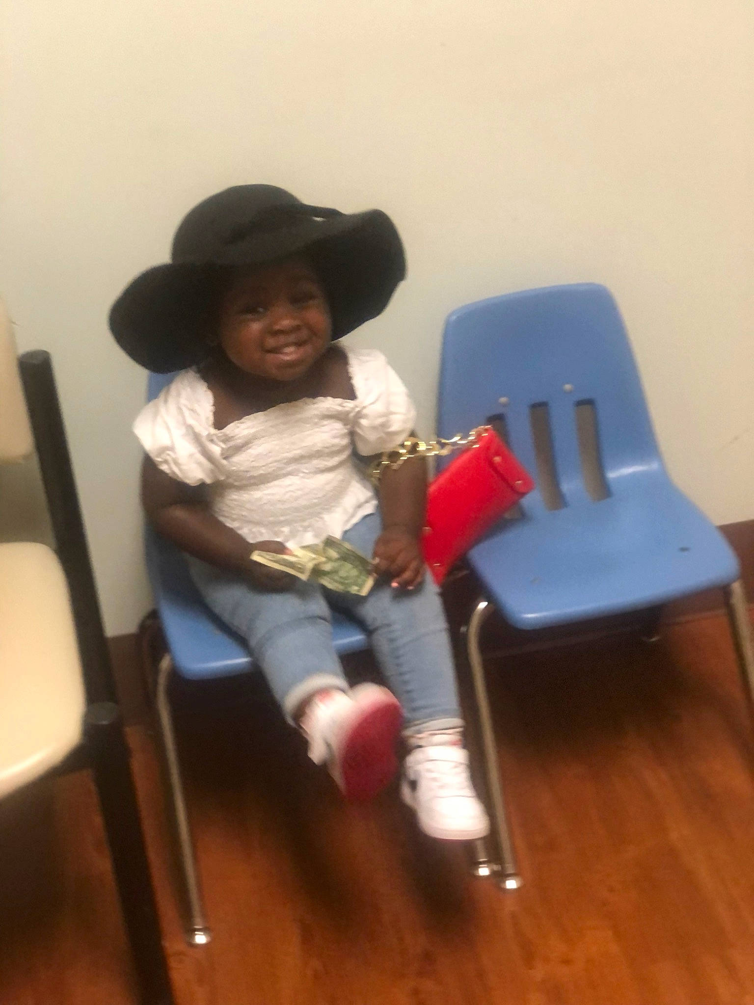 Melanie joined the competition — help win amazing prizes! baby, chair, child, comfort, floor, flooring, furniture, hardwood, hat, headwear, joy, knee, lap, person, sitting, skin, smile, sun_hat, table, thigh