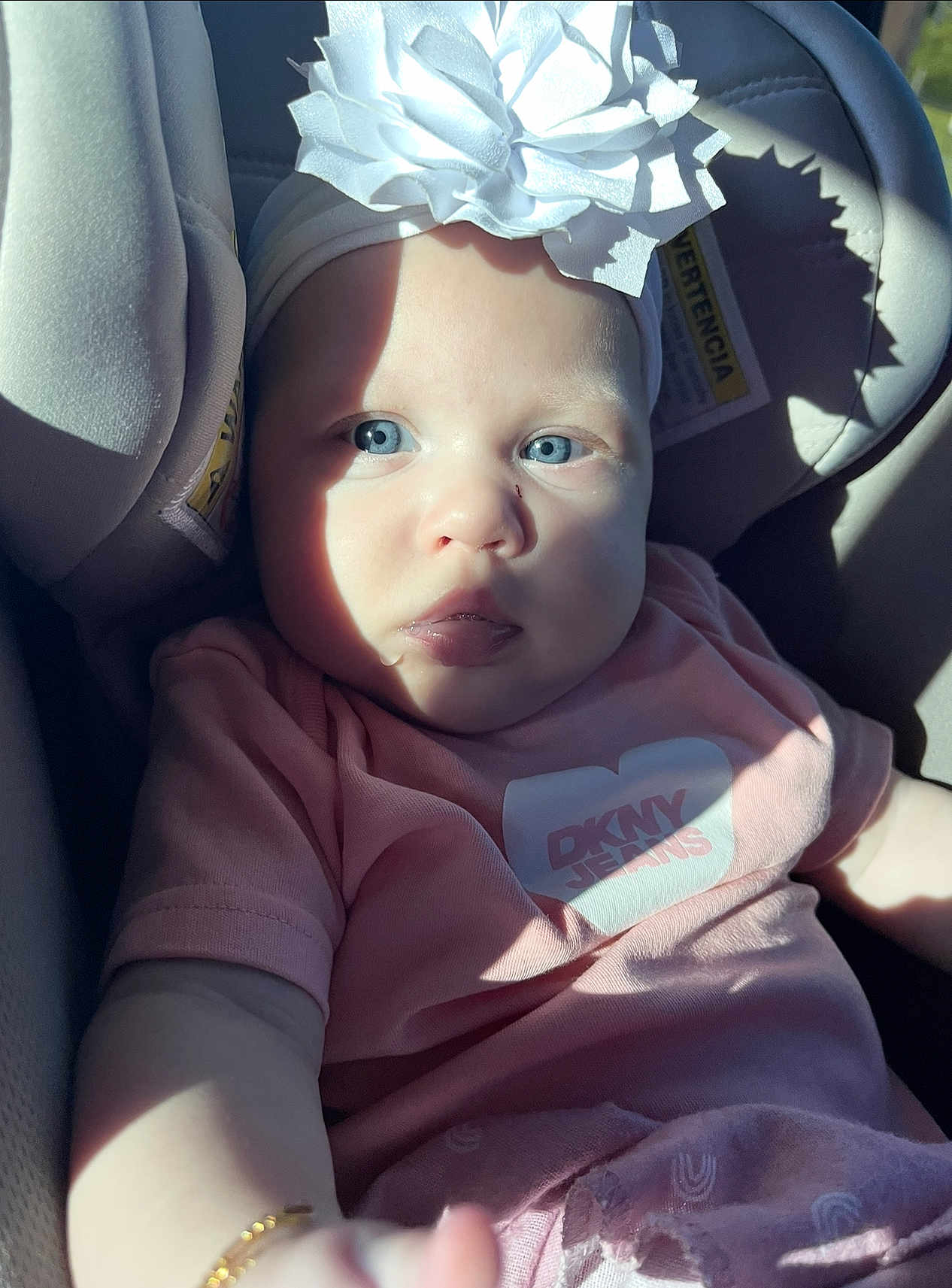 Hannah joined the competition — help win amazing prizes! baby, child, blue_eyes, headband, flower, car_seat, sunlight, shadow, pink_clothing, bracelet, infant, portrait, closeup, cute, young, person, seatbelt, fabric, indoors, soft_light