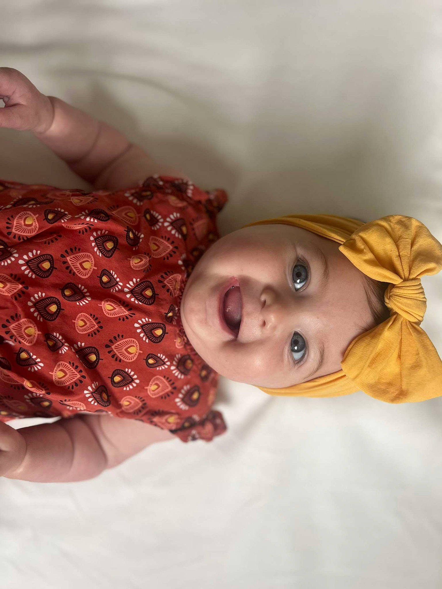 Luciana participe au concours pour gagner de l'argent avec cette photo : abdomen, baby, baby_toddler_clothing, chest, child, comfort, eyelash, fashion_accessory, happy, headwear, human_body, jewellery, linens, lip, mouth, pattern, person, room, skin, textile