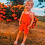 Mylana participe au concours pour gagner de l'argent avec cette photo : child, toddler, girl, standing, flowers, flower_bed, orange_flowers, garden, outdoors, summer, romper, sandals, smile, happy, portrait, grass, tree, sky, fence, hair_tie