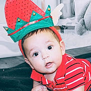 Ronen joined the competition — help win amazing prizes! baby, infant, child, face, eyes, hat, elf_hat, red_shirt, striped_shirt, hands, blanket, floor, indoors, cute, expression, holiday, festive, costume, person, portrait