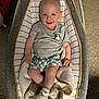 baby, infant, smiling, baby_rocker, blanket, grey_tshirt, checkered_shorts, socks, carpet, indoor, child, cute, happy, comfort, seated, portrait, young_child, person, home, cozy