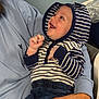 baby, child, hoodie, striped_clothing, jeans, smile, happy, person, holding, adult, hand, face, casual_wear, indoor, portrait, joy, cute, infant, clothing, interaction
