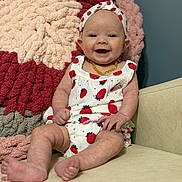 Emma Kaye is registered to the contest to win money with this photo: baby, infant, smiling, sitting, headband, strawberry_pattern, clothing, blanket, couch, happy, cute, indoor, portrait, child, furniture, skin, feet, hand, face, yellow_necklace