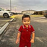 Luam joined the competition — help win amazing prizes! child, toddler, smiling, happy, portrait, red_outfit, polo_shirt, shorts, sneakers, bracelet, outdoor, parking_lot, cars, trucks, street, pavement, evening, streetlights, cloudy_sky, building