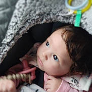 Zaylee joined the competition — help win amazing prizes! baby, child, blanket, toy, indoor, infant, cute, cozy, soft_texture, pink_clothing, curious_look, face, portrait, young_child, warm, comfort, seated, hand, head, expression