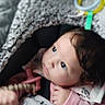 baby, child, blanket, toy, indoor, infant, cute, cozy, soft_texture, pink_clothing, curious_look, face, portrait, young_child, warm, comfort, seated, hand, head, expression