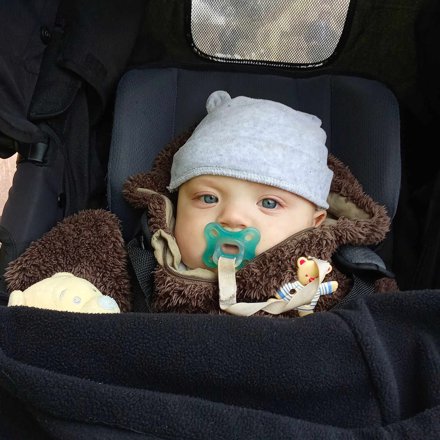 Kal El participe au concours pour gagner de l'argent avec cette photo : baby, bonnet, cap, car, clothing, coat, crib, face, furniture, hat, head, infantbed, jacket, knitwear, person, photography, portrait, toy, transportation, vehicle