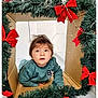 toddler, child, cardboard, holiday, decoration, greenery, red_bows, curious, indoors, festive, face, sweater, crawling, cute, young_child, christmas, framed, portrait, person, playful