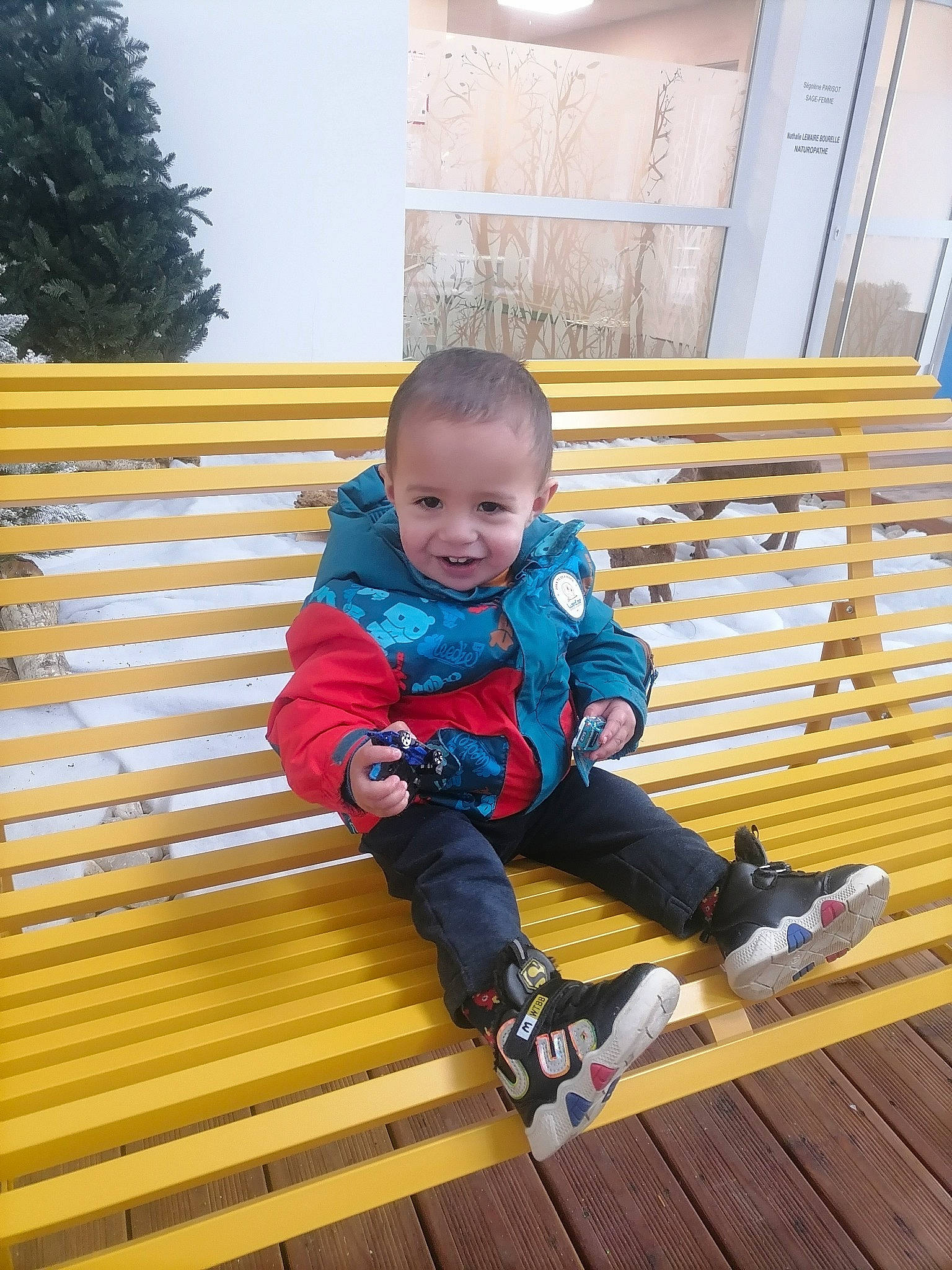 Alexandre participe au concours pour gagner de l'argent avec cette photo : baby, baby_toddler_clothing, boot, child, electric_blue, flooring, fun, happy, hardwood, joy, leg, leisure, outdoor_shoe, person, shoe, sitting, smile, sneakers, toddler, travel